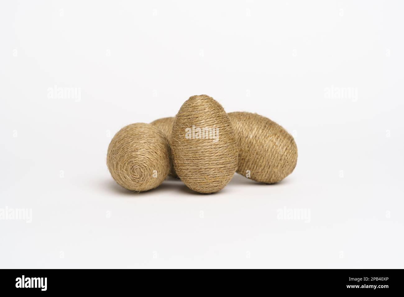 Hand wrapped easter eggs with jute twine, isolated white background. Studio Stock Photo