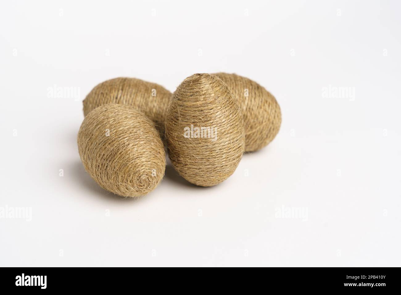 Hand wrapped easter eggs with jute twine, isolated white background. Studio Stock Photo