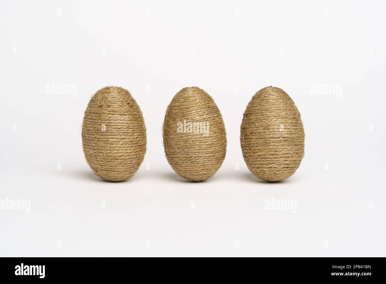 Hand wrapped easter eggs with jute twine, isolated white background. Studio Stock Photo