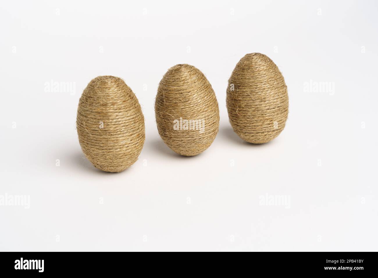 Hand wrapped easter eggs with jute twine, isolated white background. Studio Stock Photo