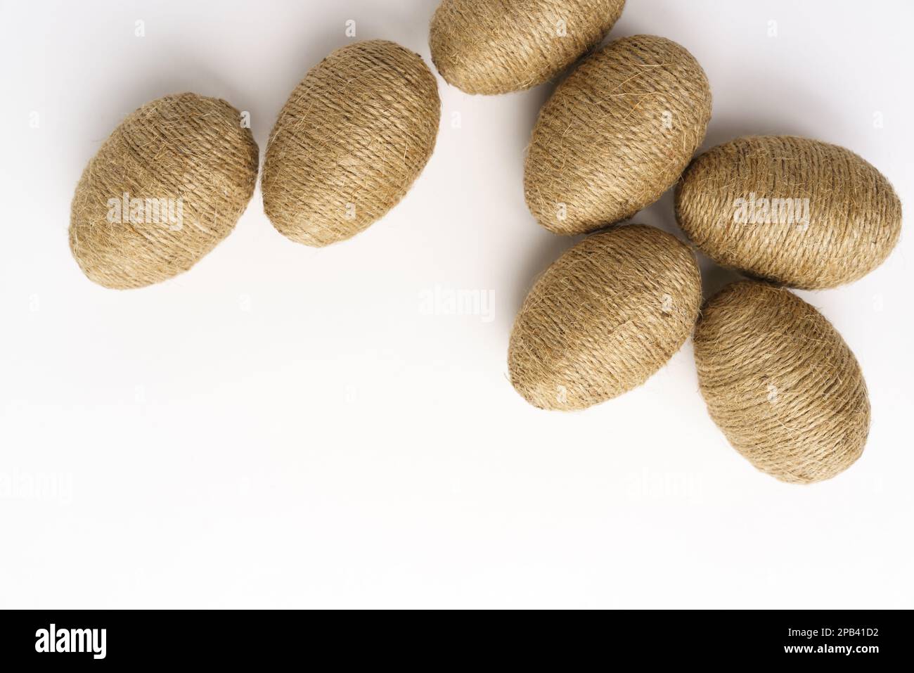 Hand wrapped easter eggs with jute twine, isolated white background. Studio Stock Photo