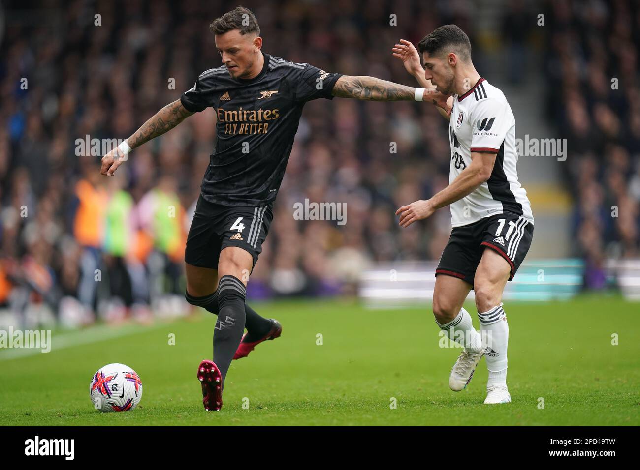 Arsenal's Ben White (left) and Fulham's Manor Solomon battle for the ball during the Premier League match at Craven Cottage, London. Picture date: Sunday March 12, 2023. Stock Photo