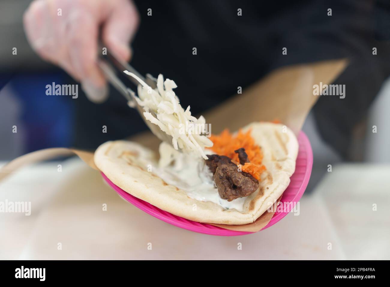 Cook puts cabbage on pita bread with grilled chicken meat. Chef ...