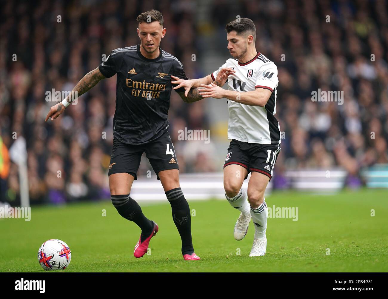 Arsenal's Ben White (left) and Fulham's Manor Solomon battle for the ball during the Premier League match at Craven Cottage, London. Picture date: Sunday March 12, 2023. Stock Photo