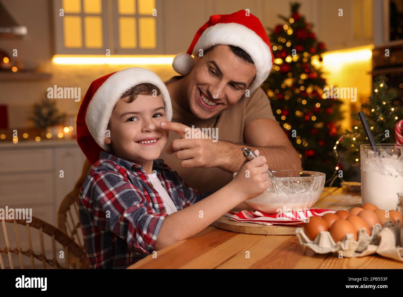 Happy father and his son making dough for Christmas cookies at home ...