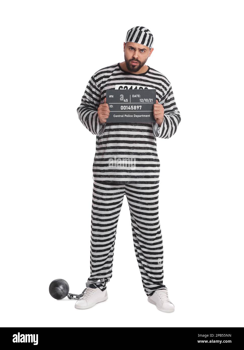Prisoner in special uniform with mugshot letter board and metal ball on white background Stock Photo