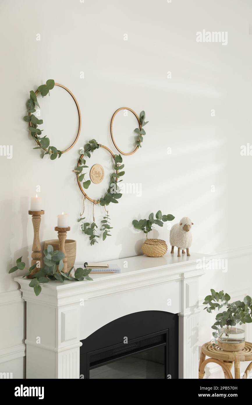Stylish room with beautiful fireplace and eucalyptus branches Stock