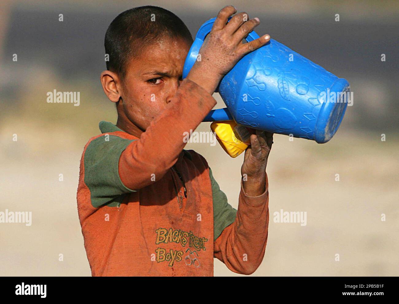 Jamsheed, an Afghan refugee, drinks water outside his temporary shelter