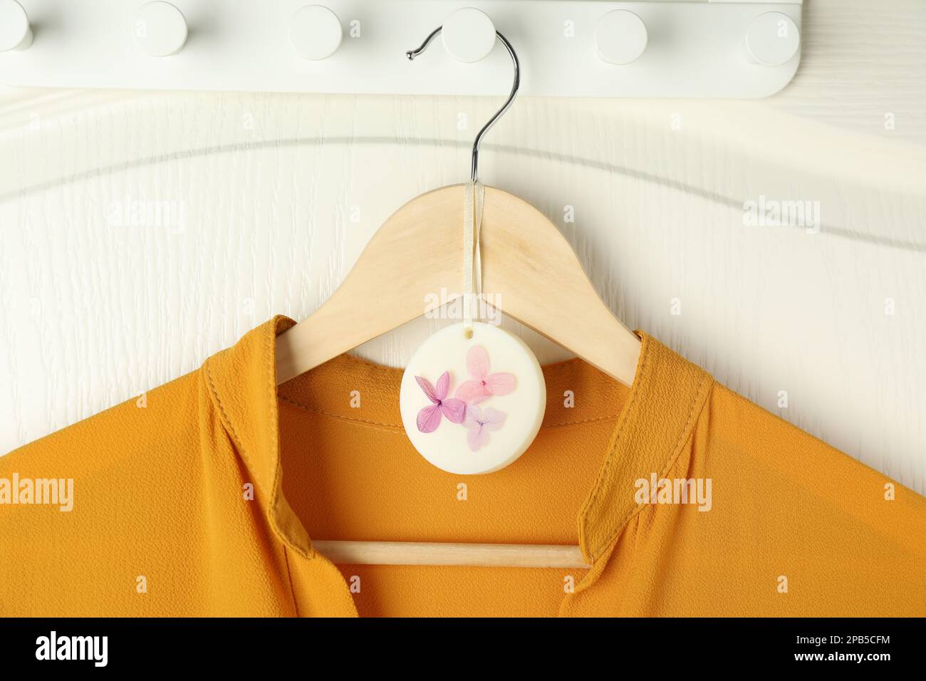 Scented sachet with flowers and stylish clothes on hanger Stock Photo