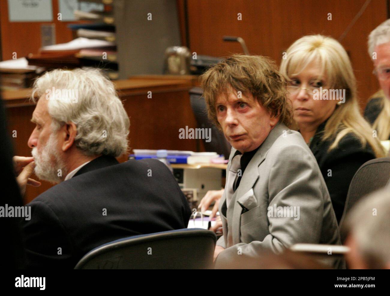 Music producer Phil Spector, center, listens to the prosecutor's