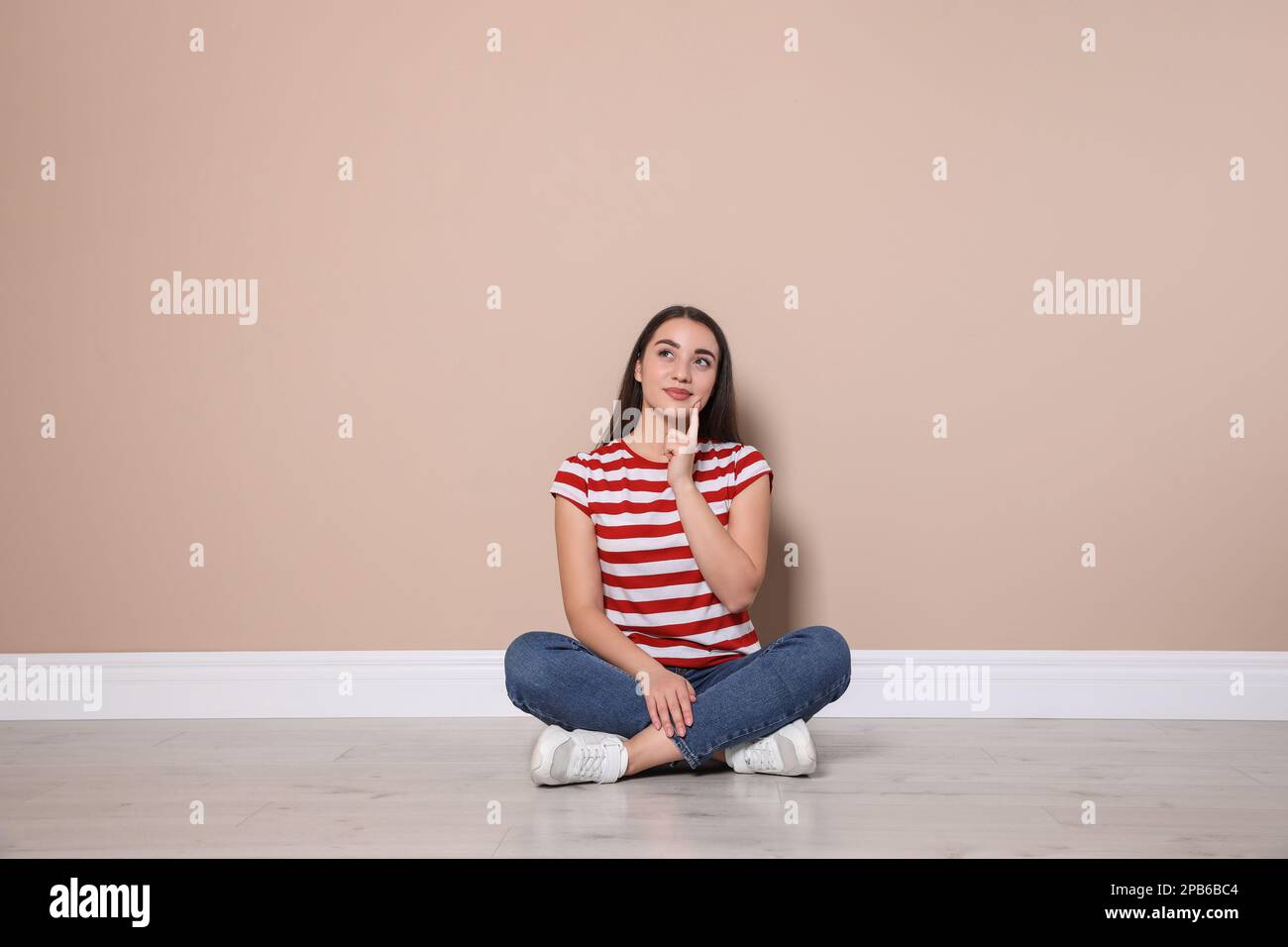 Young woman sitting on floor hi-res stock photography and images - Alamy