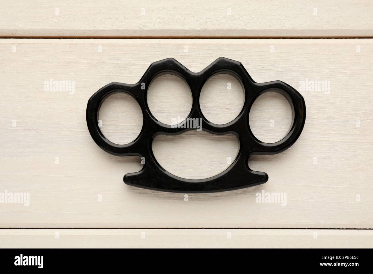 Black Brass Knuckles On Wooden Background, Top View Stock Photo