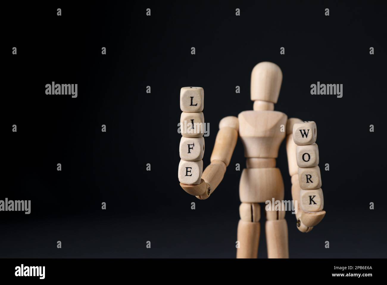 Life work balance concept. Wooden mannequin holding cubes on black ...