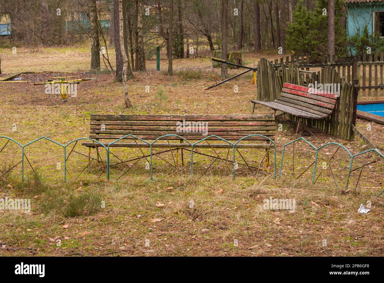 A dilapidated and forgotten bench in an abandoned resort on a gloomy ...