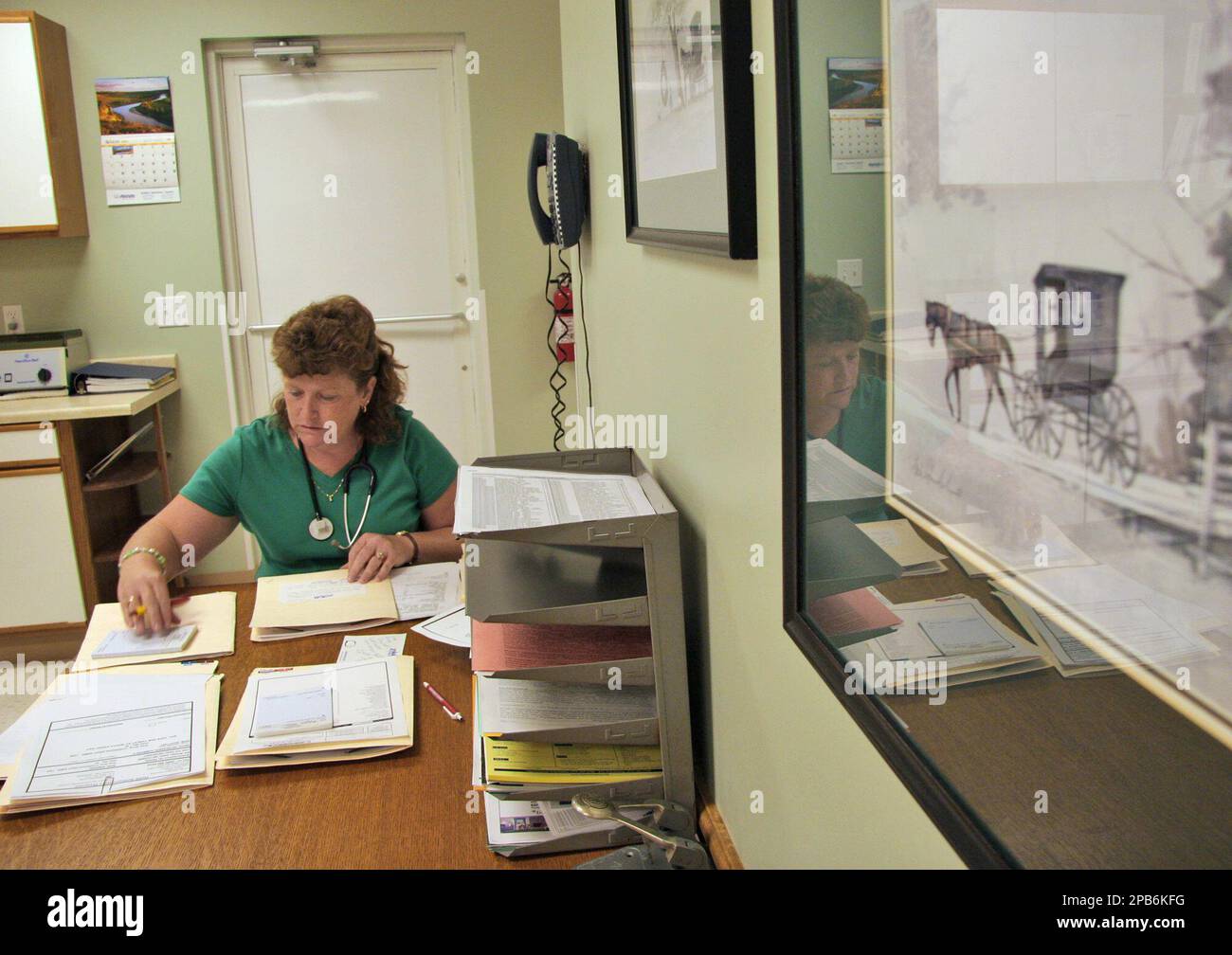 Laurie Beach, Pilot Grove, Mo, works on patient paperwork at the Pilot