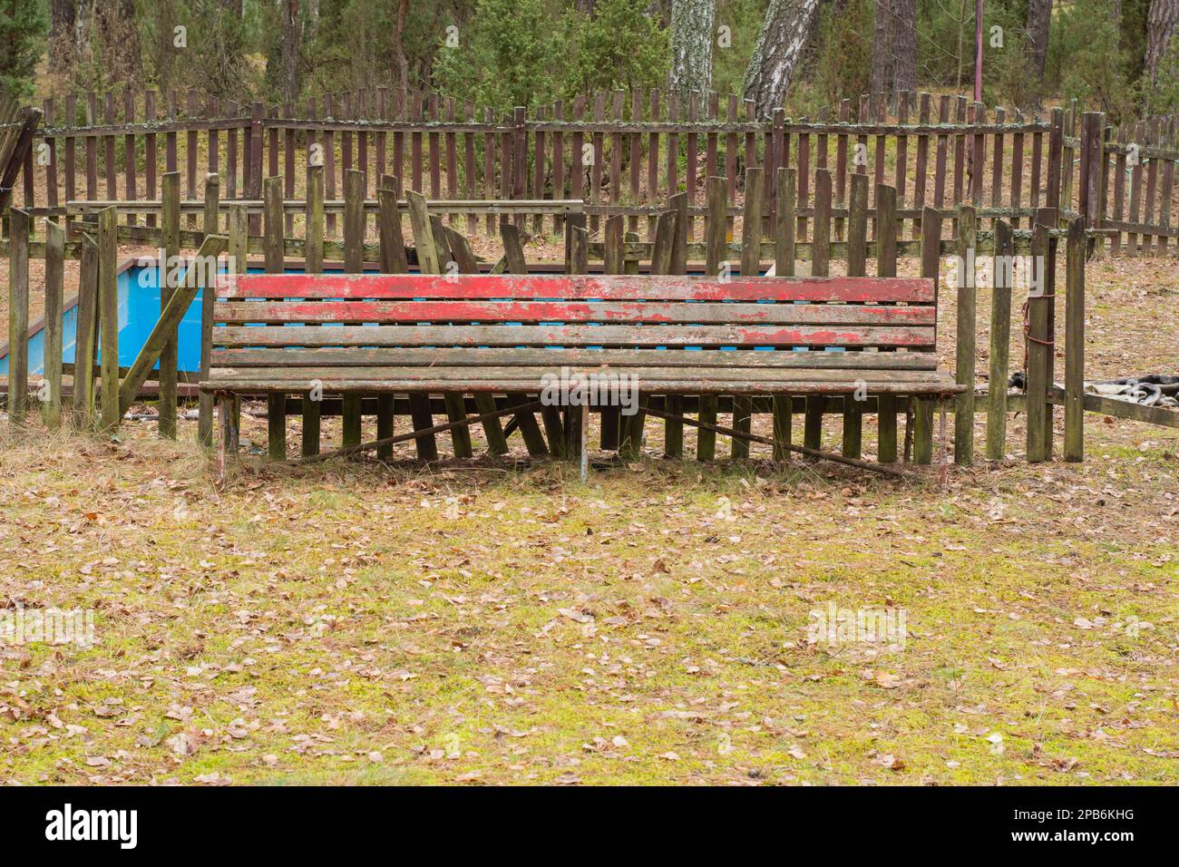 A dilapidated and forgotten bench in an abandoned resort on a gloomy ...