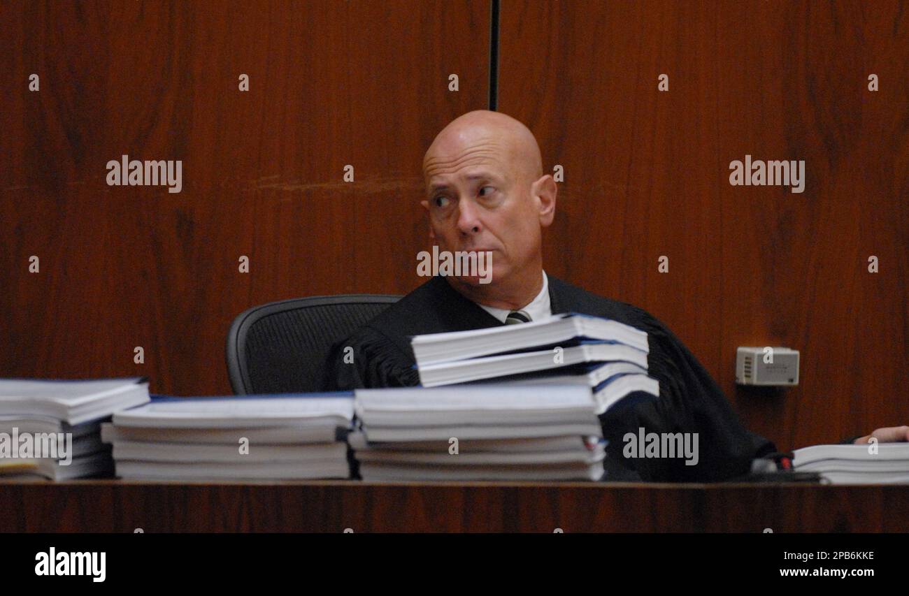 Judge Larry Paul Fidler moves some of the case transcripts across his ...