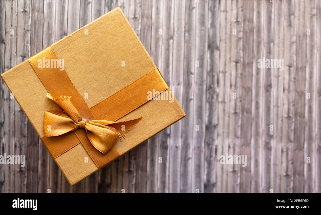 Premium Photo  Black gift with a beige ribbon on a yellow background. view  from above.