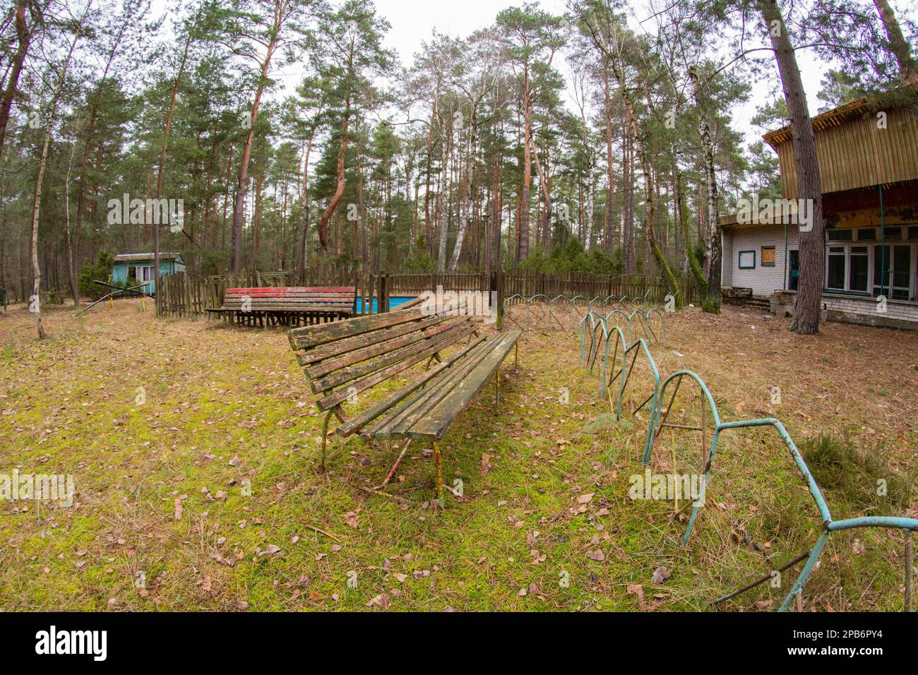 A dilapidated and forgotten bench in an abandoned resort on a gloomy ...