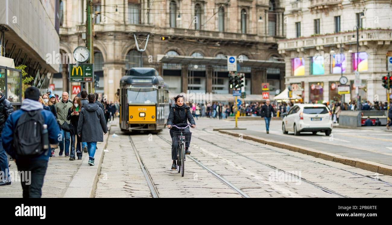 MILAN, ITALY - APRIL 2022: Tourists and locals walking down busy streets in the center of Milan, a metropolis in Italy's northern Lombardy region. Mil Stock Photo