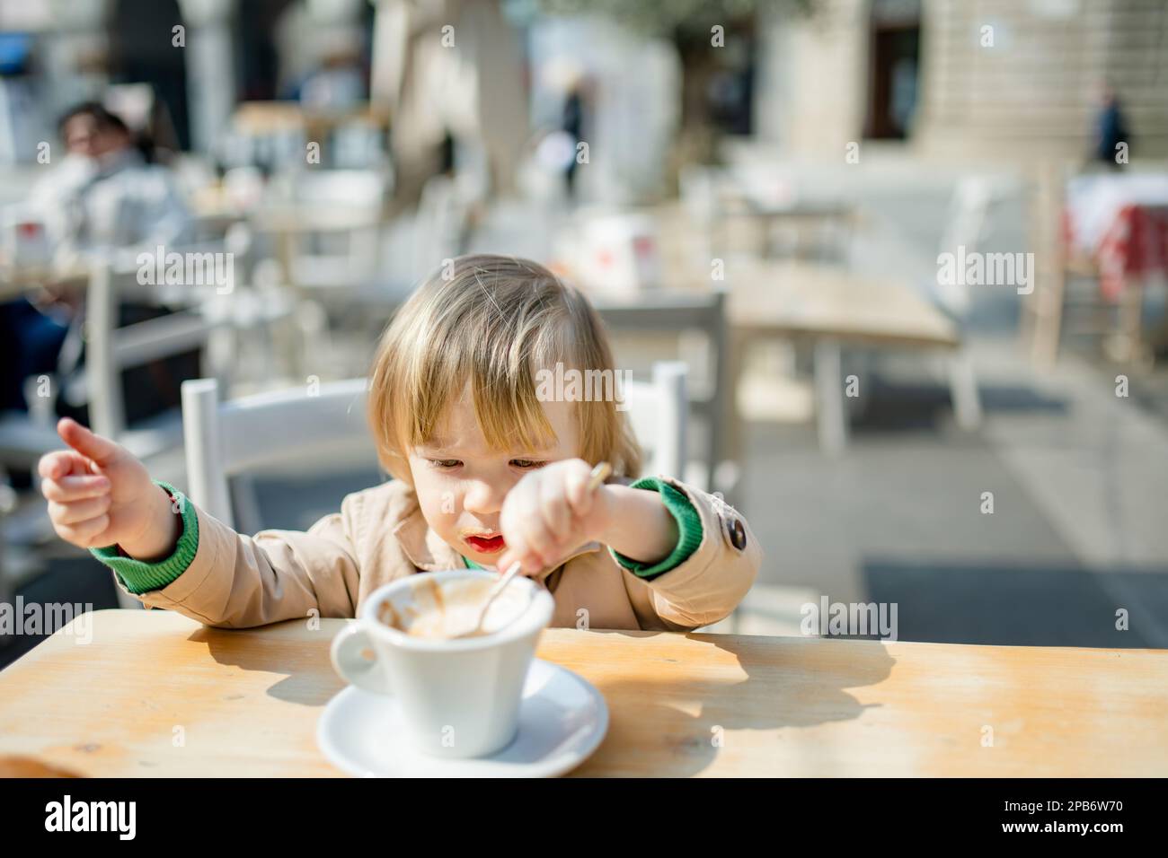 3 year old boy drinking mug of hot chocolate in a cafe Stock Photo - Alamy