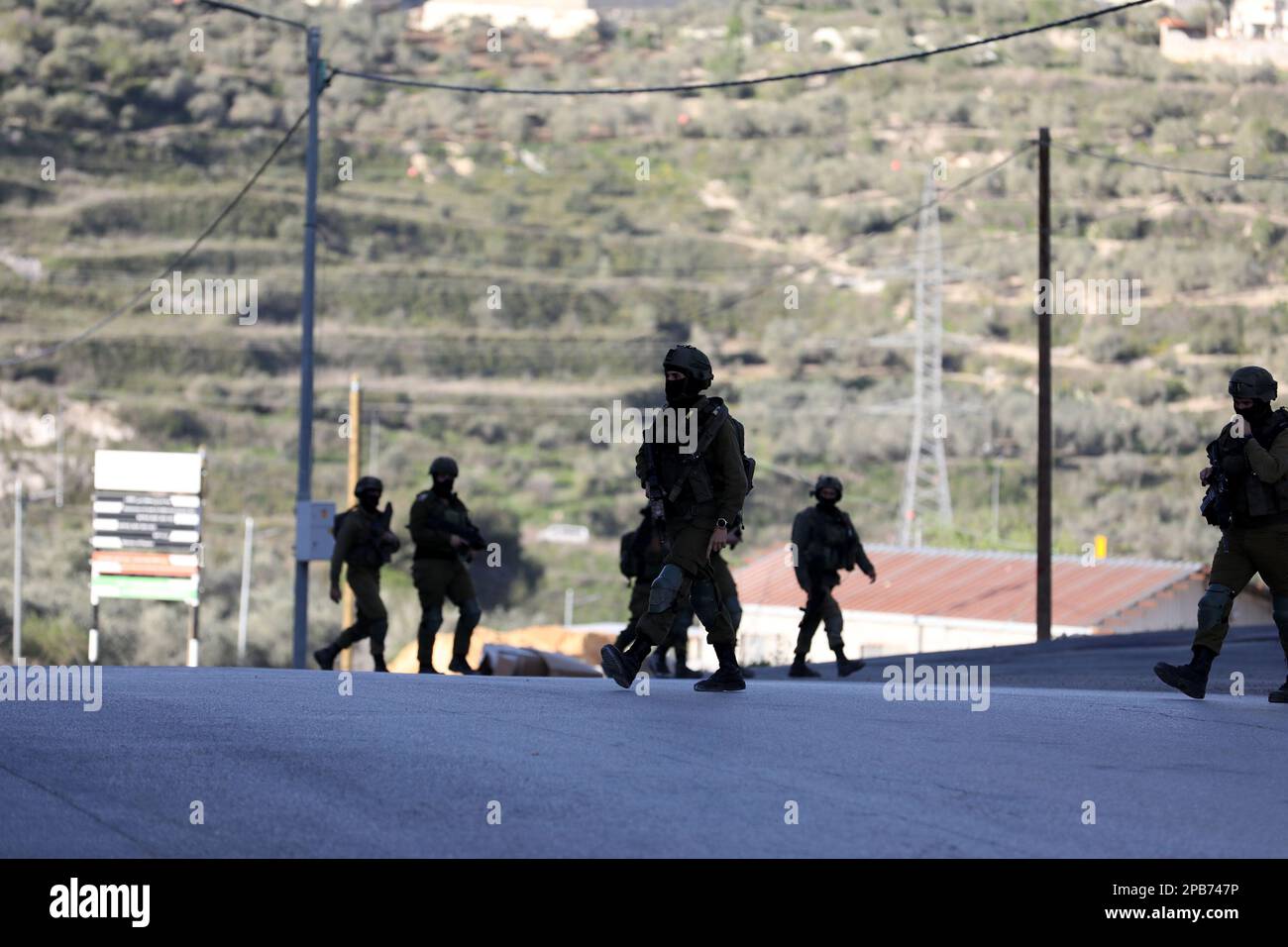 Surra, West Bank, Palestine. 12th Mar, 2023. Nablus, West Bank, Palestine. 12 March 2023. Israeli troops at the site where 3 Palestinian young men were killed on Sunday morning west of the West Bank city of Nablus. On Sunday the Israeli army announced the death of 3 Palestinian militants and the arrest of a fourth as they opened fire during a 'pre-emptive operation'' to neutralise three Palestinian gunmen in a car near the junction of the village of Surra, west of Nablus. After the operation the Israeli troops withheld the bodies of the three men and confiscated the vehicle. No Israeli casu Stock Photo