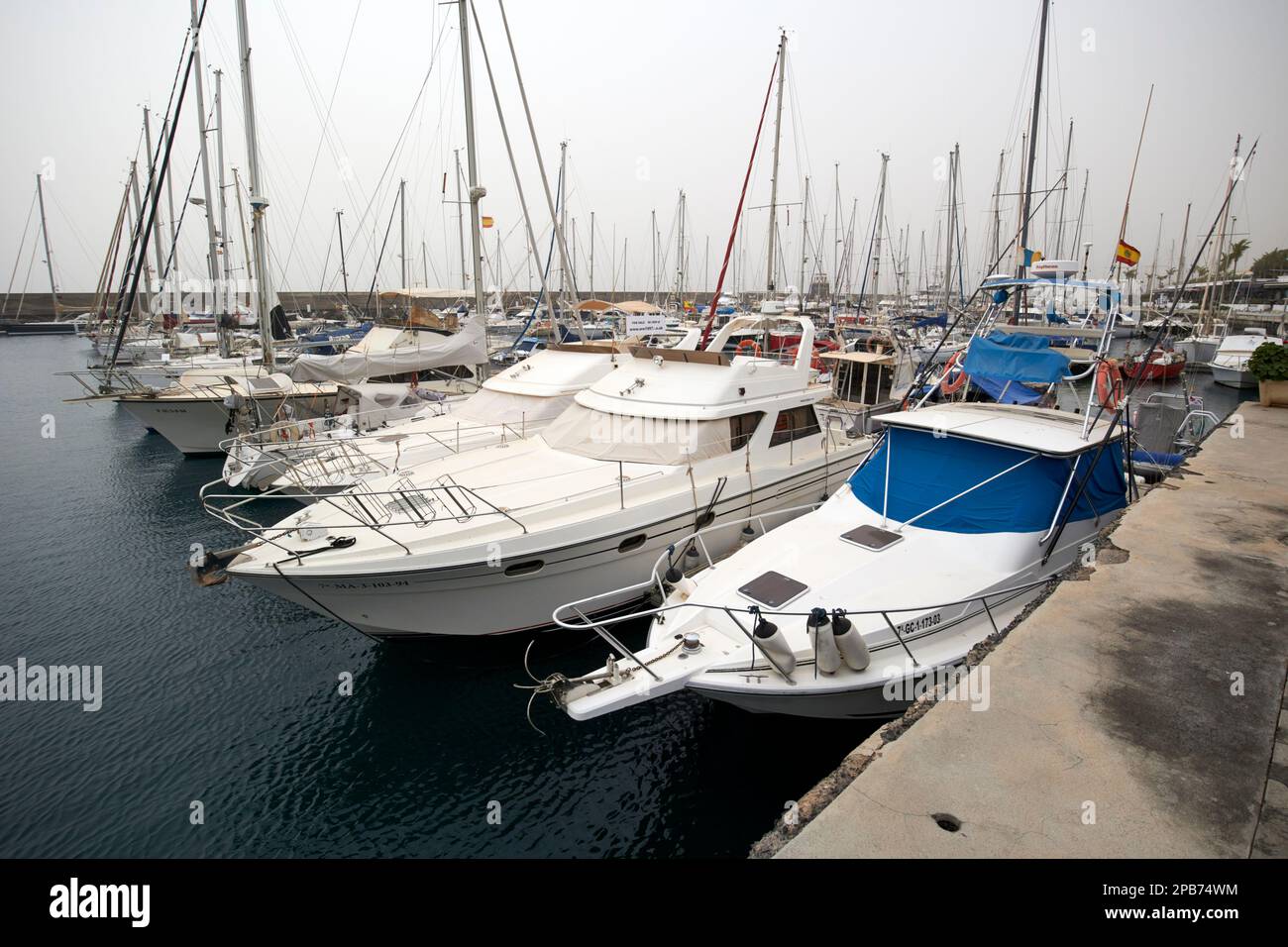 power boats and yachts with winter covers in place during calima in puerto calero marina Lanzarote, Canary Islands, Spain Stock Photo