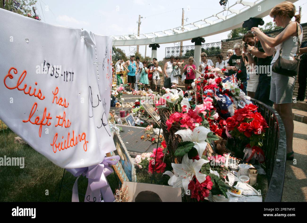 The grave of Elvis Presley is decorated with flowers and items made by