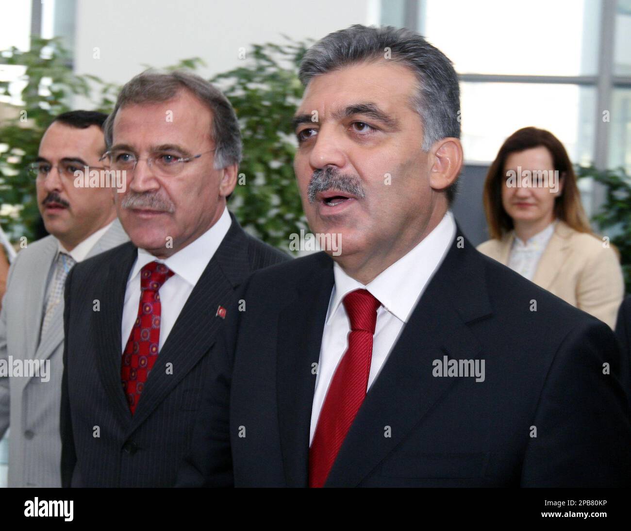 Flanked by his party officials, Sadullah Ergin, left, Mehmet Ali Sahin, second left, and Nukhet Hotar, rear,Turkish Foreign Minister Abdullah Gul, right, arrives at the headquarters of the opposition Nationalist Action Party, MHP, to meet with MHP leader Devlet Bahceli in Ankara, Tuesday, Aug 14, 2007. Gul, once again seeking to become Turkey's president, sought support from opposition leaders Tuesday, altought some parties fear he will undermine secular traditions and provoke the ire of the powerful military. The MHP pledged to attend the voting process in the legislature, enabling the ruling Stock Photo