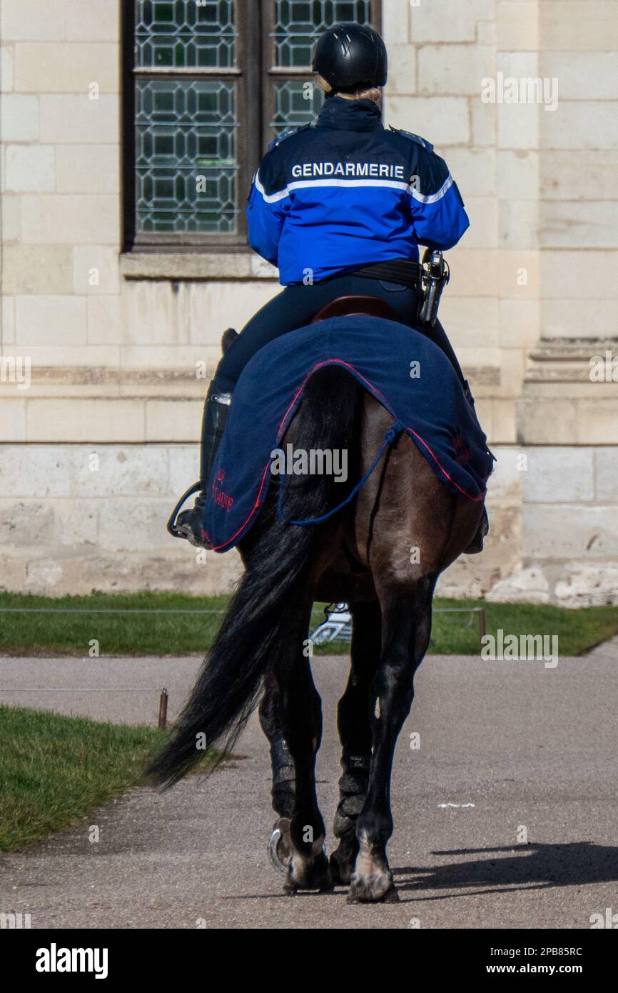 Chambord, France. February 25, 2023. French gendarme on a horse seen from behind with inscription gendarme on his jacket Stock Photo