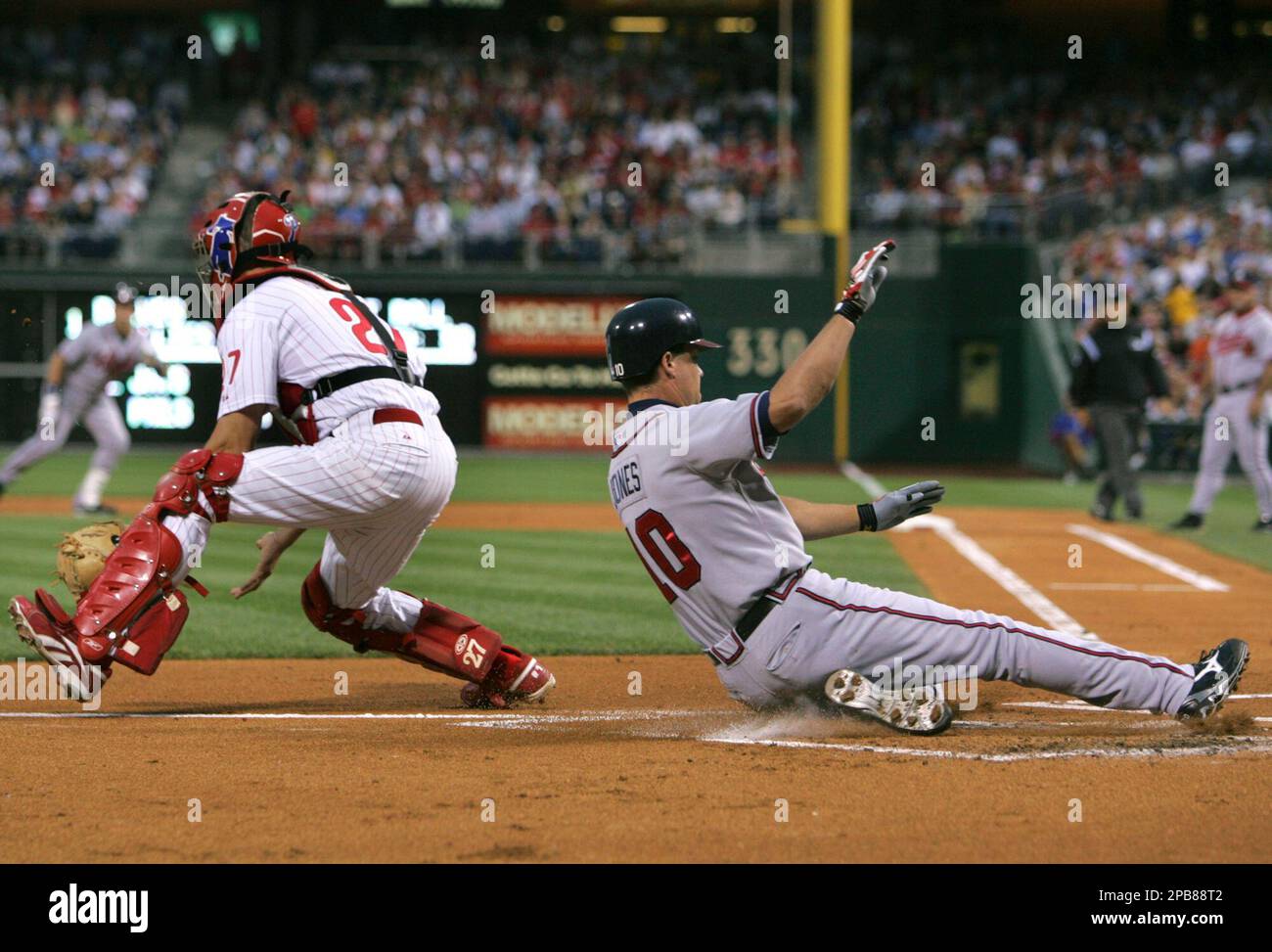 Atlanta Braves' Chipper Jones slides across the plate to score 