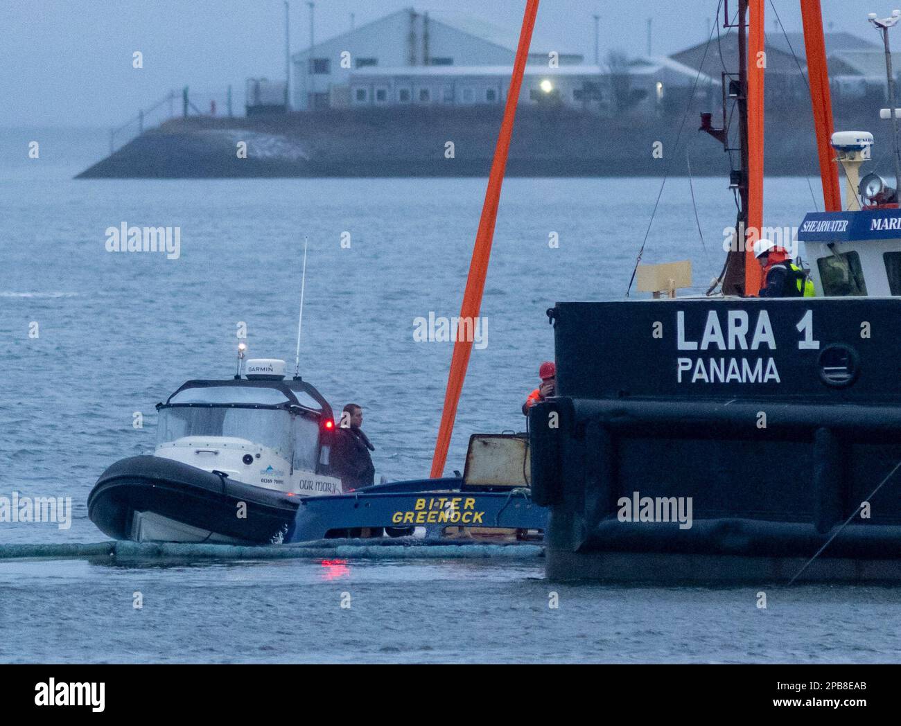Salvage teams at Victoria Harbour recover a tugboat from the water in