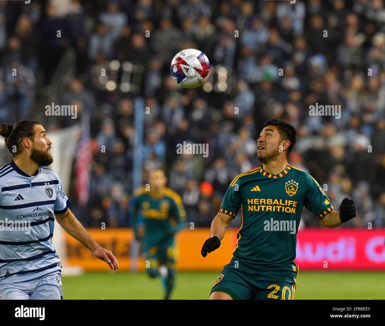 Kansas City, USA. 16th Nov, 2022. Los Angeles Galaxy midfielder Memo Rodríguez (20, right) and Sporting Kansas City midfielder Graham Zusi (8) watch the ball drop. Sporting KC hosted the LA Galaxy in a Major League Soccer game on March 11, 2023 at Children's Mercy Park Stadium in Kansas City, KS, USA. Photo by Tim Vizer/Sipa USA Credit: Sipa USA/Alamy Live News Stock Photo