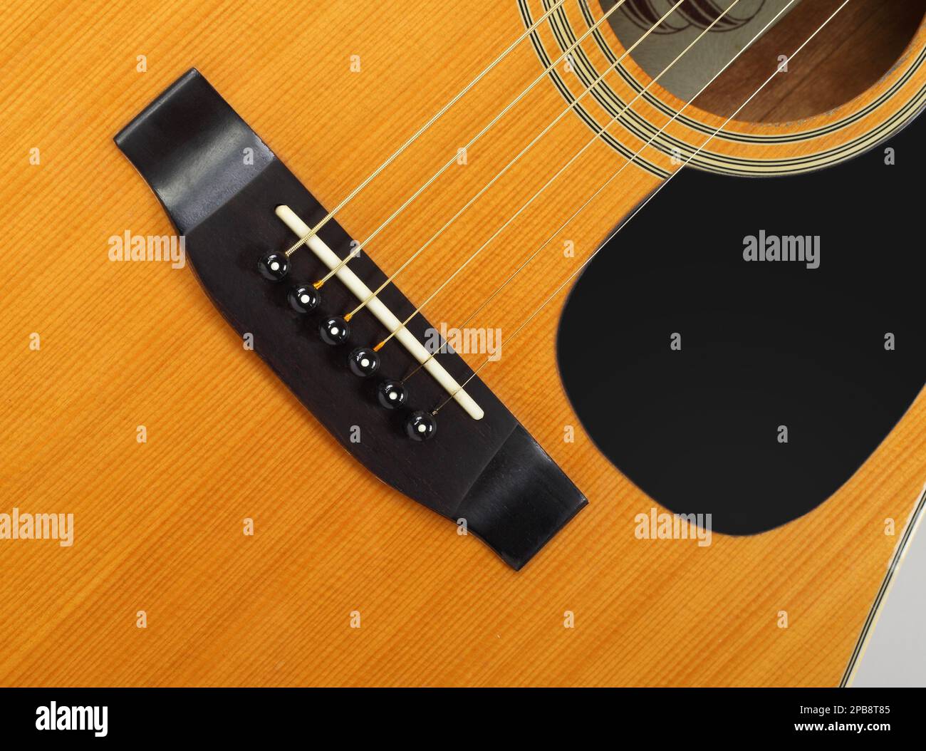 Musical instrument - Fragment top view pickguard, bridge, pins and strings vintage acoustic guitar. Stock Photo