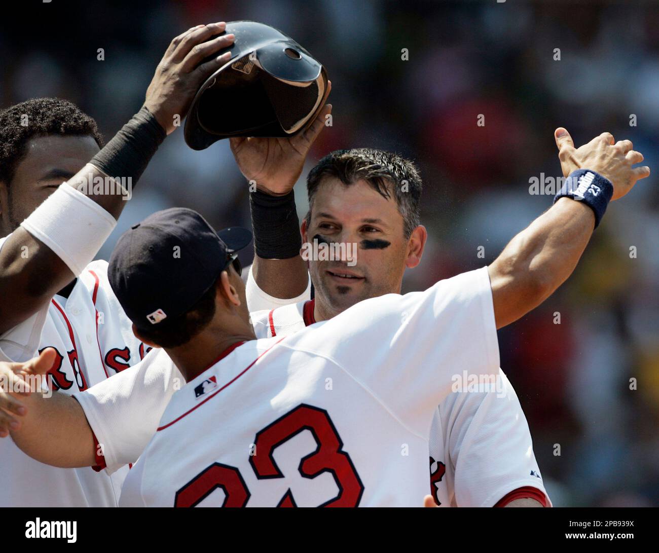 Boston Red Sox's Doug Mirabelli receives a hug from Julio Lugo (23) as  David Ortiz, left, pulls off Mirabelli's batting helmet after he hit a solo  home run against the Baltimore Orioles