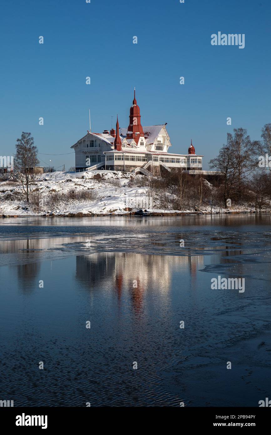 Restaurant Saaristo reflecting from partly frozen sea on Luoto or Klippan islet on a sunny winter day in Helsinki, Finland Stock Photo
