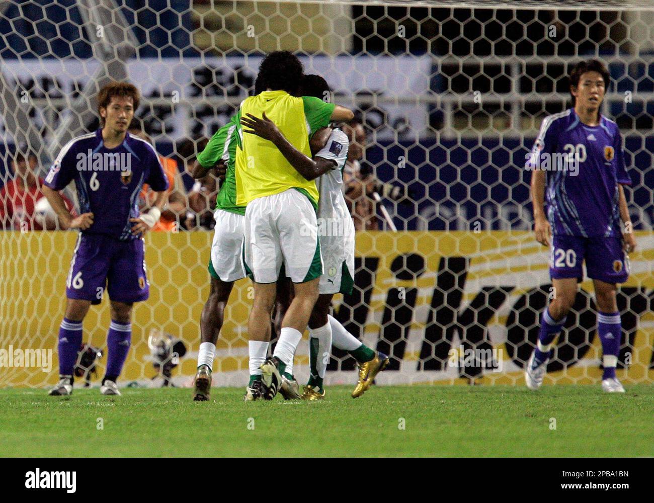 Japan's Yuki Abe (6) and Kisho Yano (20) stand still while Saudi Arabia's  players celebrate their 3-2 victory against Japan after Asian Cup soccer  semifinal match at My Dinh Stadium in Hanoi,,