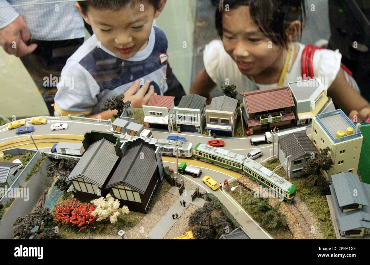 Kids are excited to watch model trains of popular street car Enoshima electric trains known as Eno Den that run between Japanese seaside cities of Kamakura and Enoshima south of Tokyo during an