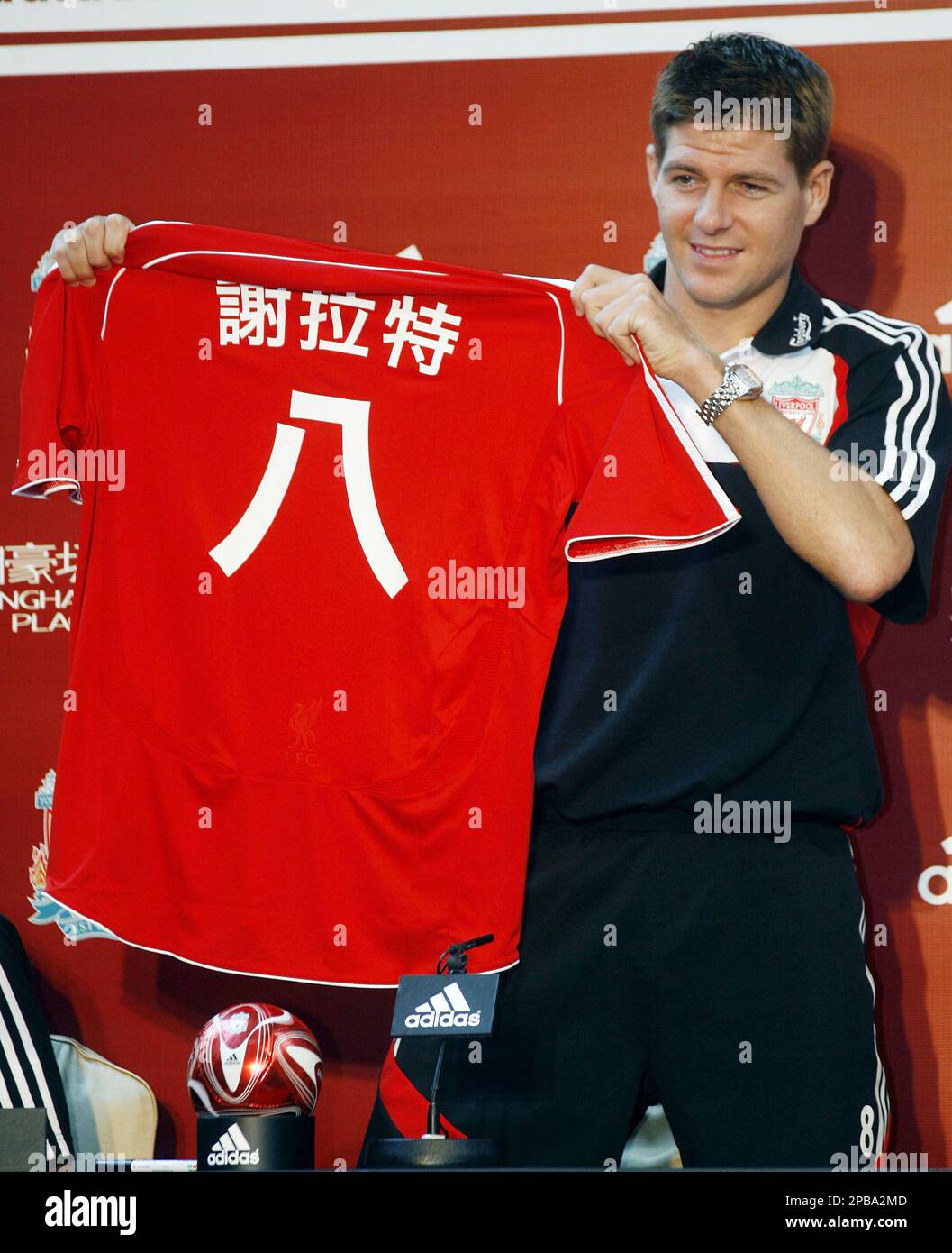 Liverpool s captain Steven Gerrard raises a jersey displaying his name and number 8 written in Chinese during a fan session in Hong Kong Wednesday July 25 2007. England s Liverpool Portsmouth and Fulh...