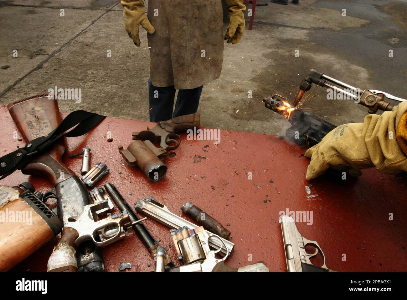 A police officer cuts a gun in half with acetylene, a highly flammable