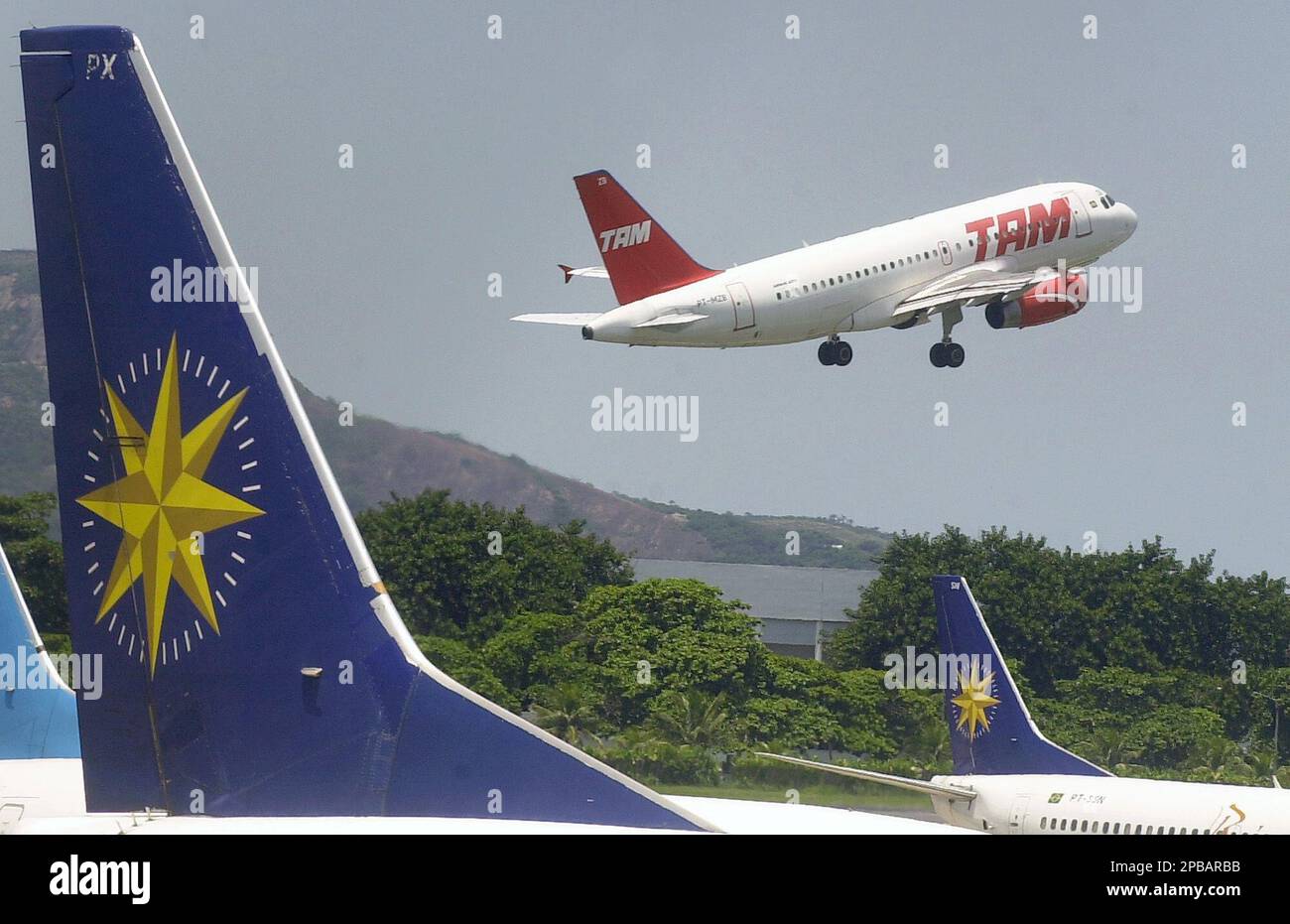 FILE **A plane of TAM airlines takes off as a Varig plane is stationed at  Santos Dumont airport in Rio de Janeiro, Brazil, in this Thursday, Feb. 6,  2003, file photo.