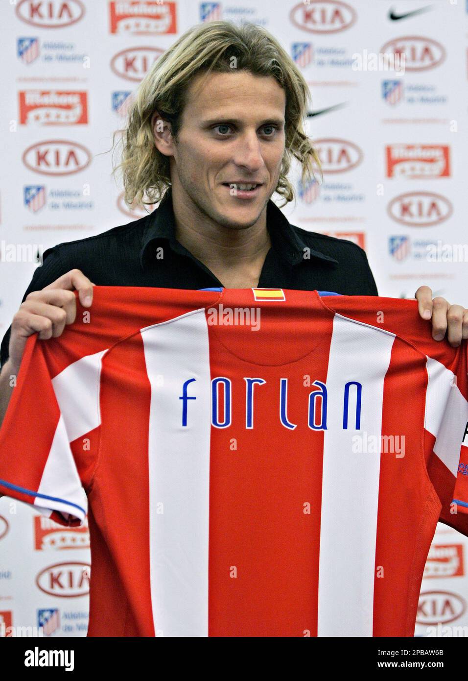 Diego Forlan of Uruguay holds up his new shirt during his official  presentation for Atletico Madrid at the Vicente Calderon stadium in Madrid,  Tuesday July 17, 2007. Forlan previously played for Villarreal,