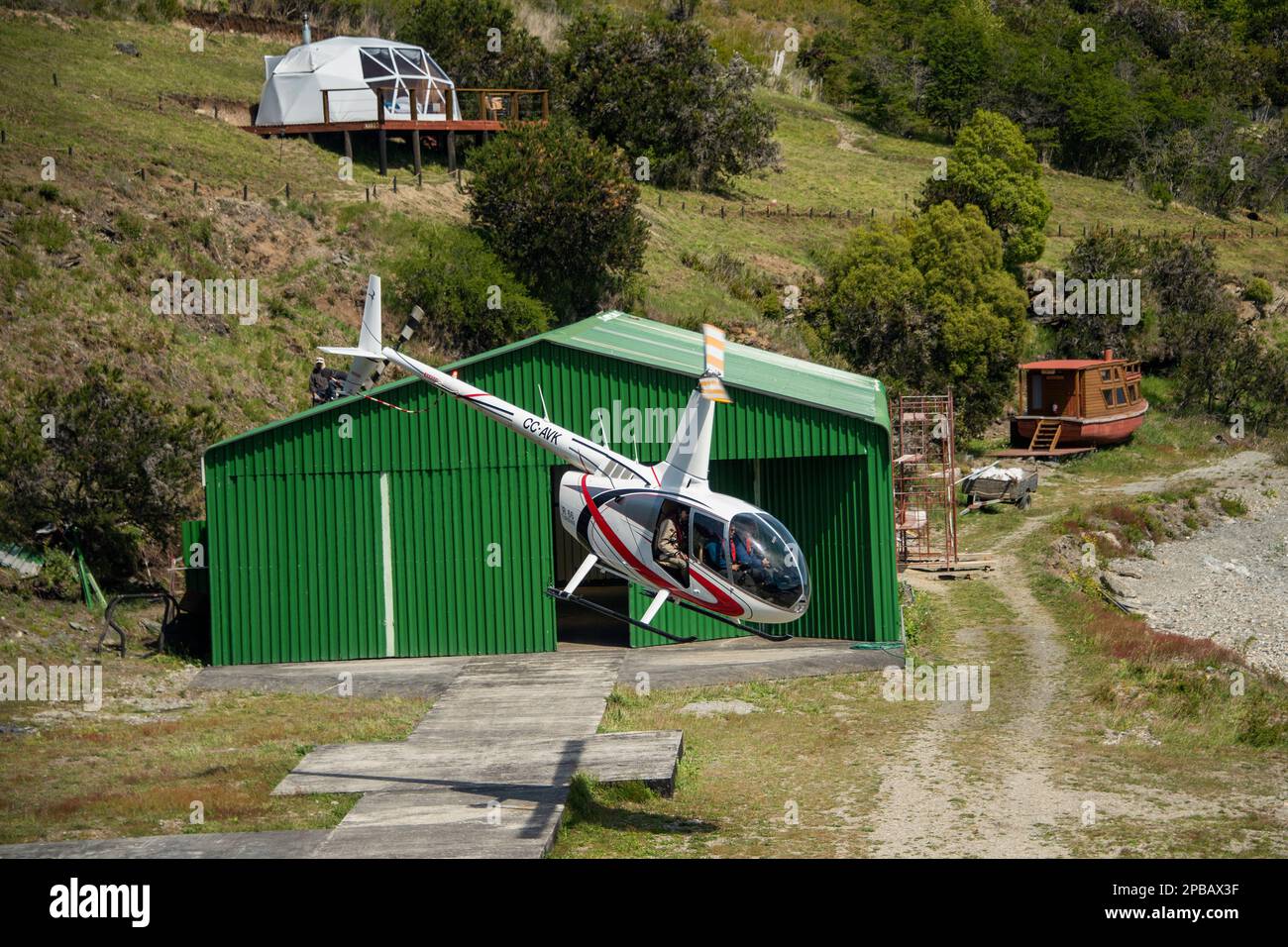 Open door helicopter taking off from Terra Luna Lodge for the Parque Nacional Laguna San Rafael, Puerto Guadal, Patagonia Stock Photo