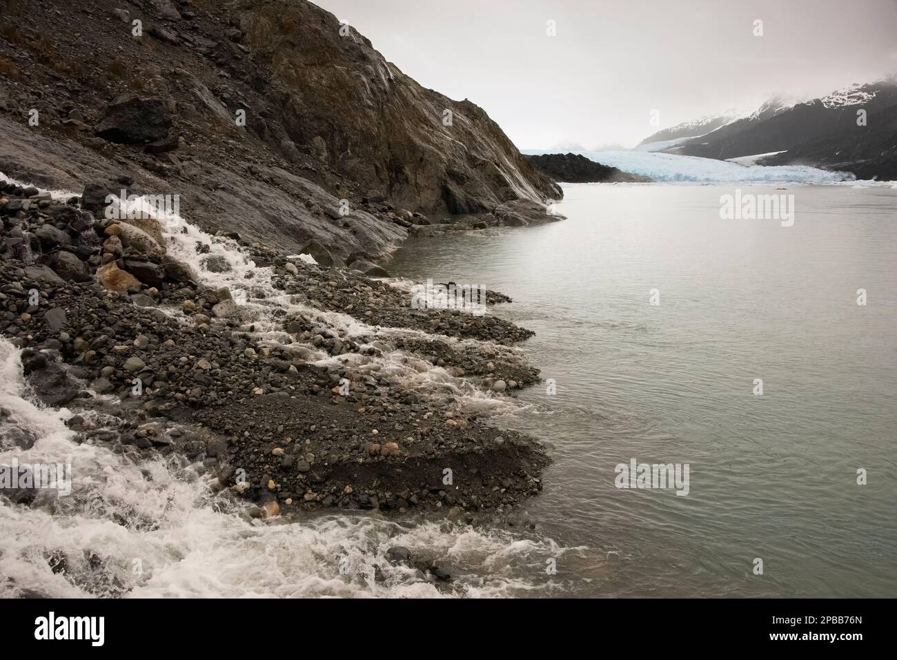 Waterfall and debris from the retraction of the Jorge Montt Glacier, Tortel, Patagonia Stock Photo