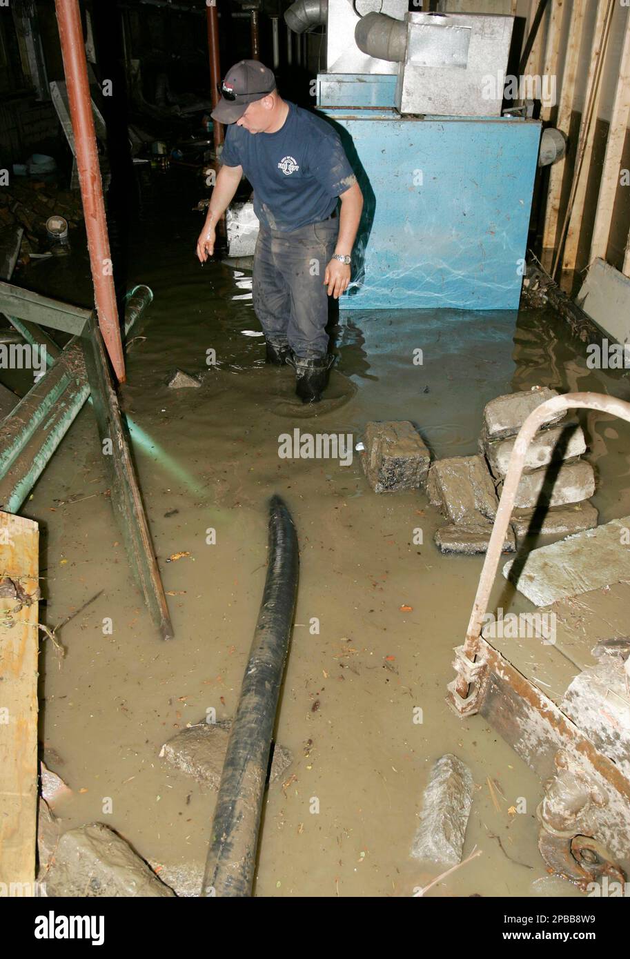 Barre firefighter Jeff Cochran inspects the flooded basement of the Old  Labor Hall, a National Historical Landmark, in Barre, Vt., Thursday, July  12, 2007, after severe flooding from the rain-swollen Winooski River, image size:913x1390