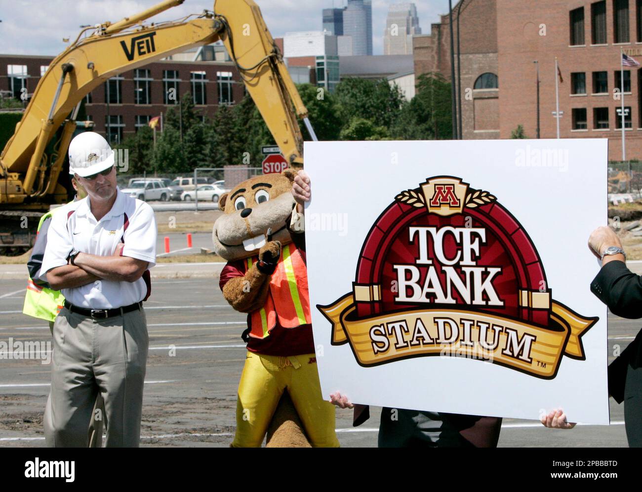 Minnesota football coach Tim Brewster, left, looks on as mascot Goldy