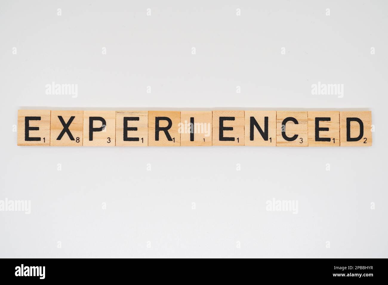 Wooden title spelling the word experienced isolated on a white background Stock Photo