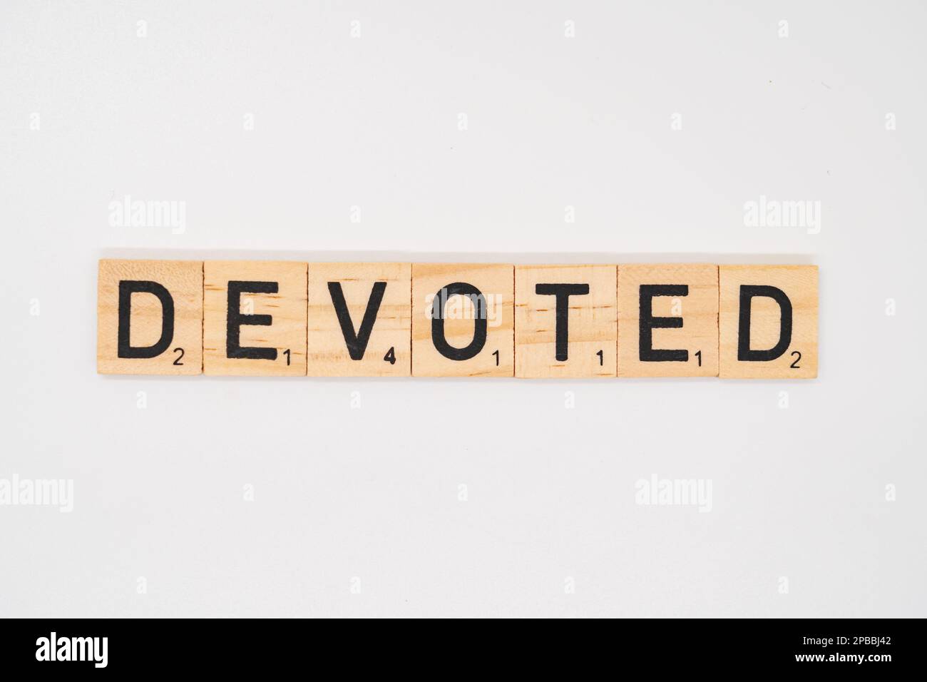 Wooden title spelling the word devoted isolated on a white background Stock Photo