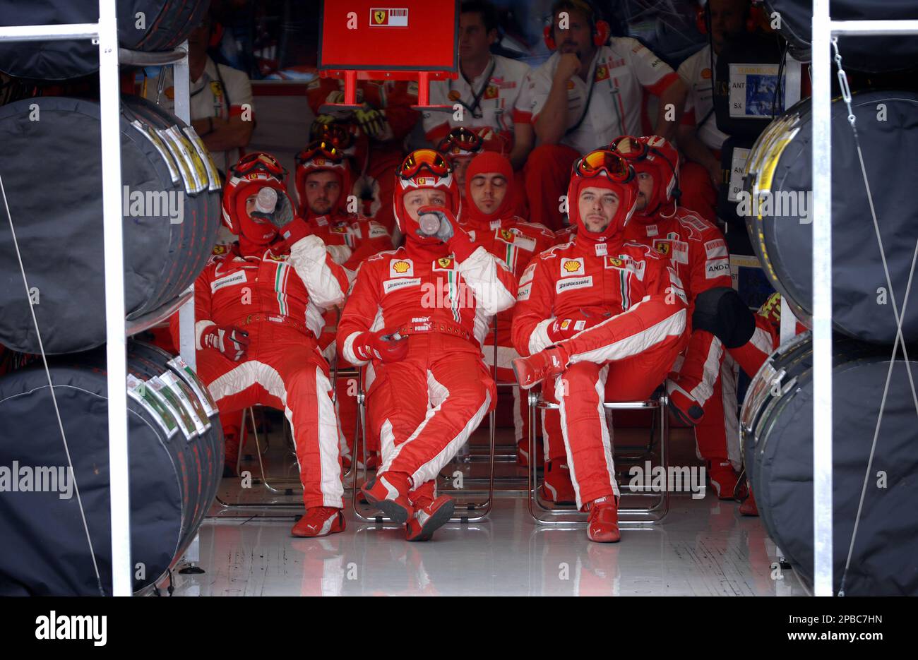 Ferrari mechanics watch the race on a control screen as they sit in their pits during the French Formula One Grand Prix in Magny-Cours, central France, Sunday July 1, 2007.(AP Photo/POOL/Martin Bureau