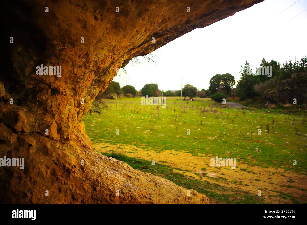Rock arch with a green meadow in the background Stock Photo - Alamy